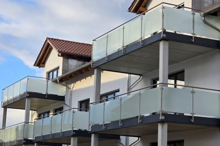 Edelstahlgeländer mit Milchglas Moderne Wohngebäude mit Balkonen und bruchsicherem Glasgeländer.